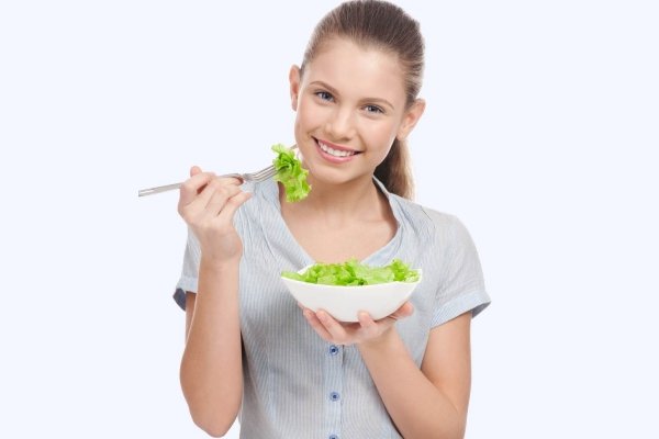 Девочка-подросток ест салат